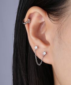 Enhance your look with our shining star chain earrings! These stunning earrings require two ear piercings for a charming and unique style. Add a touch of glamour to any outfit and make a bold statement with these must-have accessories. Detail： -Post material: gold plated with internal stainless steel or stainless steel. Cubic Zirconia -Gauge: 20g | 0.8mm-Post length: 6mm-Star dimensions: 4mm Length x 4.2mm Width -Chain length: 34mm-Include: single item -Closure: screw ball back * Shop extra ball Two Ear Piercings, Ear Piercing Studs, Ear Chain, Ear Style, Titanium Earrings, Star Chain, Daily Jewelry, Into Fashion, Jewelry Lookbook