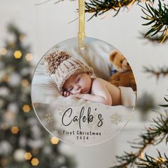 a baby's first christmas ornament hanging from a tree