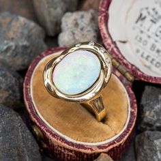 This exquisite vintage cocktail ring is centered with one (1), semi-bezel set, oval cabochon cut natural opal doublet. The opal is bordered with four (4), flush set, round brilliant cut diamonds. The ring measures 18.4mm at the top, rises 6.2mm above the finger, tapering to 2.6mm wide and 1.0mm thick at the base of the shank. This ring is currently a size 5.5. Luxury Cabochon Engagement Ring, Luxury Cabochon Opal Ring, Classic Cabochon Opal Ring, Heirloom Oval Opal Ring For Formal Occasions, Elegant Ethiopian Opal Ring With Oval Cabochon, Fine Jewelry Oval Cabochon Opal Ring, Oval Cabochon Opal Ring Fine Jewelry, Oval Cabochon Opal Ring In Fine Jewelry, Formal Hallmarked Oval Cabochon Opal Ring