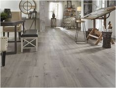 a living room filled with furniture and a wooden floor covered in lots of wood planks