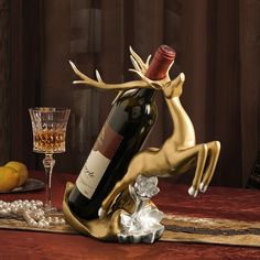 a bottle of wine is sitting on a table next to a glass and an antler