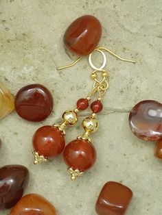 Enjoy creamy, richly colored genuine Carnelian gemstone beads accented with 14k and 18k real gold-plated pins, bead caps, and beads. Choose from three styles: (1) Two Carnelian beads with two gold plate bead caps and a gold plate bead in the middle. (2) Three Carnelian beads with one gold plate bead cap and gold-plated tiny beads. (3) Three Carnelian beads with two flat faceted gold plate beads. Your choice of hooks includes: (1) Gold-plated stainless steel French hooks (shown on Style 1). (2) Gold-plated stainless steel lever back hooks (shown on Style 2). (3) Gold plated copper lever back hooks (shown on Style 3). (4) Gold plated copper adjustable screw clip on hooks. These earrings measure about two inches (5 cm) from top to bottom. This varies a little with the style and hooks chosen. Adjustable Carnelian Earrings With Natural Stones, Handmade Adjustable Carnelian Earrings, Carnelian Round Earrings With Ear Wire, Carnelian Drop Earrings With Natural Stones, Carnelian Natural Stones Dangle Earrings, Autumn Princess, Plate Earrings, Gold Chain Earrings, Carnelian Earrings