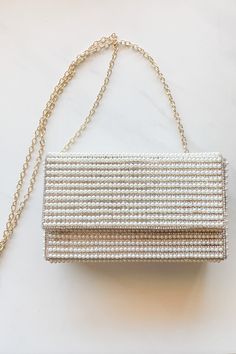 Look your best for that special moment with the Going To The Chapel Clutch! This stylish bridal bag is decked out with beautiful pearl and rhinestone accents and comes with an extra chain link strap so you can grab-and-go like nobody's business. Perfect for the bride-to-be or as a gift for that special someone, this clutch will make you say "I do" (to looking fabulous, that is). White Wedding Bag With Chain Strap, Chic Evening Bag With Chain Strap For Wedding, Elegant Party Bag With Pearl Chain, Elegant Party Bags With Pearl Chain, Formal Bags With Pearl Chain, Elegant Bags With Pearl Chain, Elegant Evening Bags With Pearl Chain, Glamorous Bag With Pearl Handle For Wedding Guest, Glamorous Bags With Pearl Handle For Wedding Guest