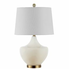 a white table lamp with a gold base and a white shade on the top of it