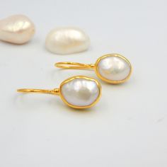 "White Fresh Water Baroque Pearl Drop Earrings. Sterling Silver 18k Gold Plated, 100% Handmade Unique Statement Earrings. PEARL: This enchanting June birthstone originates from oceans, lakes and rivers around the world. It is a timeless wardrobe staple, beloved by women of all ages. Pearls have long been associated with purity, humility and innocence. So it may be said that the June birthstone meaning is \"sweet simplicity.\" As such, pearls were traditionally given as a wedding gift. THE EARRIN Handmade Gold-plated Bridal Earrings For Wedding, Anniversary Bridal Earrings With Pearl Drop In Yellow Gold, Anniversary Bridal Earrings In Yellow Gold With Pearl Drop, Anniversary Yellow Gold Bridal Earrings With Pearl Drop, White Gemstone Round Bridal Earrings, Oval Pearl Jewelry For Wedding, Oval Pearl Wedding Jewelry, Pearl Earrings In Yellow Gold For Wedding, Gold Bridal Earrings With Gemstones