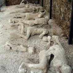 some statues are laying on the ground in an area that is covered with rocks and gravel