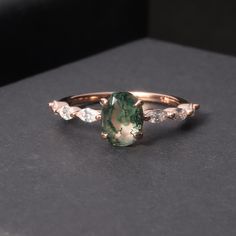 Experience the beauty and uniqueness of our Oval Moss Agate Classic Engagement Ring. The stunning oval-shaped Moss Agate stone is known for its calming and grounding properties, making it the perfect symbol of love and commitment. Show your partner how much they mean to you with this timeless and meaningful ring. Main Stone: Moss Agate, 6x8mm  Side Stones: Colourless Zircon Accents VS to VVS clarity Band: 1.4-1.6mm bandwidth Band Material: 14k Gold, 18k Gold, Platinum Conflict-Free  ** This item is 100% handmade, which requires 3 weeks lead time. Custom Gemstone Rings, Meaningful Rings, Moss Agate Stone, Classic Engagement Ring, Classic Engagement, Classic Engagement Rings, Agate Gemstone, Everyday Jewelry, Agate Stone