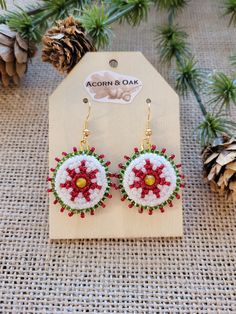 These Poinsettia themed Yellow Agate Beaded Medallion earrings are hand beaded by a registered Tribal Artist of the Choctaw Nation. Ruby red, emerald green and pearl glass seed beads create a seven printed poinsettia flower motif around a center 4mm yellow agate stone. The earrings hang from a gold-tone nickel free ear wire and have a green felt backing for comfort. Adjustable Round Beaded Earrings For Festive Occasions, Festive Beaded Earrings With Round Beads, Beaded Flower Earrings Gift, Gift Red Beaded Earrings With Bead Caps, Round Beaded Flower Earrings For Gifts, Handmade Red Flower Earrings For Festive Occasions, Festive Beaded Round Earrings, Handmade White Beaded Earrings For Christmas, Handmade Flower Earrings For Festive Occasions