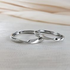 two wedding rings sitting on top of a bed