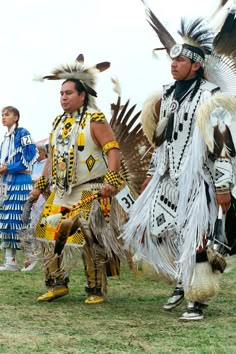 two men dressed in native american clothing standing next to each other