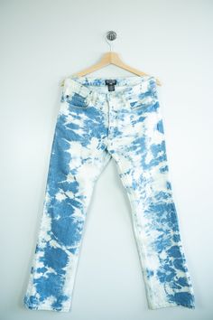 a pair of blue and white jeans hanging on a hanger