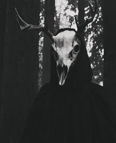 a black and white photo of a deer's head wearing a hooded jacket with horns