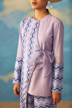 Editor's Note Presenting A Whole Vacay Vibe Sugarplum Set In A Periwinkle Shade Of Blue With Asymmetric Tunic Paired Together With Straight Leg Pants. The Base Fabric Used Is Rayon And Cotton Lurex With Detailing Of Cut Dana Work. Color: Purple Fabric: Rayon And Cotton Lurex Care: Dry Clean Only About the Designer Rishi & Vibhuti label combines traditional elements with modern aesthetic uniquely to create chic occasion wear for women with a fine choice. The global appeal in their designs has mad Tunic With Pants, Asymmetric Tunic, Designer Kurti Patterns, Tunic Designs, Long Kurti Designs, Cord Set, Salwar Kamiz, Kurta Neck Design, Coord Set