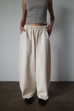 Our take on the everyday pant. Made with an elegantly curved leg, comfortable elastic waist band and large front patch pockets. This pant seamlessly blends comfort and style. An instant classic. Model is 5'6" and wearing the size small. Baggy Wide-leg Bottoms With Patch Pockets, Baggy Wide Leg Bottoms With Patch Pockets, Relaxed Wide Leg Parachute Pants With Pockets, Elevated Casual Wide-leg Pants With Pockets, Relaxed Cotton Pants With Side Pockets, Relaxed Baggy Bottoms With Elastic Waistband, Relaxed Pants With Pockets For Elevated Casual Look, Elevated Casual Wide Leg Pants With Side Pockets, Wide Leg Relaxed Fit Parachute Pants With Side Pockets