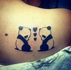 a couple of panda bears sitting on top of each other with hearts in their mouths