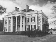 black and white photograph of the front of a large building with columns on it's sides