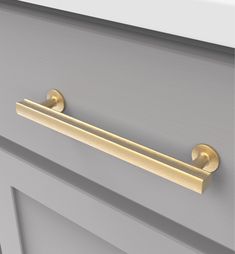 a close up of a door handle on a gray cabinet with gold handles and knobs