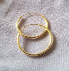 The absolute classic: the Creole, always elegant and beautiful! Material: 925 sterling silver gold plated Diameter: 25mm, Hollow Wire Thickness: 1.5mm Closure: the classic sliding closure Shape: round Please note: These classic hoop earrings are made of a hollow wire. To close it, the thinner wire must be pulled through the earlobe and then inserted into the hollow wire. If the creole stays in the ear for a long time, this clasp is very suitable because the earrings do not come open quickly, whi Classic 14k Gold Open Circle Jewelry, Adjustable Yellow Gold Round Pendant Jewelry, Formal Small Hoop Brass Jewelry, Elegant Nickel-free Gold Rings, Adjustable Minimalist Jewelry With Shiny Finish, Everyday Gold Plated Jewelry With Shiny Finish, Elegant Hypoallergenic Round Band Jewelry, Everyday Yellow Gold Jewelry With Shiny Finish, Classic Cadmium-free Yellow Gold Jewelry