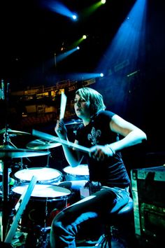 a person sitting in front of a drum set