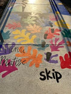 the sidewalk is painted with colorful flowers and words