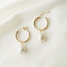 Elegant, classic, and makes a style statement. Our Claudette gold hoop earrings have the most beautiful baroque pearls and will become a staple in your outfits. Pearls symbolize wisdom acquired through experience. The pearl is also said to symbolize the purity, generosity, integrity, and loyalty of its wearer. Pearls are the birthstone for June. Baroque pearls are organically shaped and no two pearls are exactly alike in shape, and we will pair a set that looks beautiful together. As the shapes Gold Dangle Hoop Earrings For Wedding, Delicate Gold Hoop Earrings For Wedding, Delicate Yellow Gold Hoop Earrings For Wedding, Dainty Yellow Gold Hoop Earrings For Wedding, Handmade Elegant Pearl Hoop Earrings, Elegant Handmade Hoop Pearl Earrings, Elegant Handmade Pearl Hoop Earrings, Elegant Pearl Hoop Earrings With Ear Wire, Gold Hoop Bridal Earrings With Pearl Drop