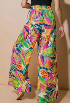 •Tropical Patterned Flowy Pants •Bright bold colors •Elastic waist •Wide leg •100% polyester •Hand wash cold •Tumble dry low •Matching top sold separately Trendy Multicolor Straight Leg Wide Pants, Summer Wide Leg Pants With Floral Print, Summer Wide Leg Floral Print Pants, Summer Floral Print Wide-leg Pants, Casual Bottoms With Bold Print For Spring, Printed Wide Leg Summer Pants, Casual Printed Pants For Vacation, Green High Waist Printed Bottoms, Multicolor Printed Wide Leg Vacation Pants