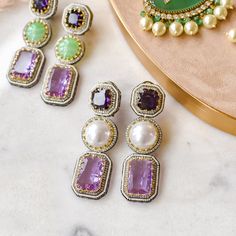 Look ravishing and take your love for long dangle earrings to another level! Gorgeous pair of earrings luxuriously studded with amethyst, pearl and CZ stones - perfect to wear them in your favorite fancy events to make all eyes rest on you. Approximate earrings length is 3.2". Designed over high-quality brass as base metal with silver and gold plating. Made by order. Kindly allow 4-6 weeks for the delivery of this item. For custom or urgent requests, please contact support@alacouture.com. *Please Note: We use faux stones and beads in all of our jewelry Fine Jewelry Earrings With Gemstone Accents For Party, Fine Jewelry Party Earrings With Gemstone Accents, Luxury Drop Earrings With Gemstone Accents, Elegant Purple Earrings For Pierced Ears, Dangle Earrings With Gemstone Accents In Cubic Zirconia, Dangle Earrings With Cubic Zirconia And Gemstone Accents, Dangle Earrings With Gemstone Accents And Cubic Zirconia, Luxury Gemstone Accented Earrings For Party, Party Drop Earrings With Gemstone Accents