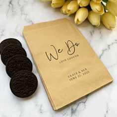 two oreo cookies sitting on top of a table next to a brown paper bag