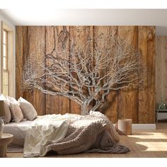 a bedroom scene with focus on the bed and tree wall mural in the background,