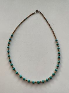 This beautiful Navajo Turquoise and Heishi Beaded Necklace adds a touch of western charm to any outfit. The stunning combination of turquoise and heishi beads creates a gorgeous, chic look that is sure to make a statement. Elevate your style with this unique and eye-catching necklace! Turquoise & Heishi Beaded Necklace 16" Long Navajo Beads are natural and may vary Rustic Adjustable Turquoise Beaded Necklaces, Rustic Turquoise Beaded Necklaces, Artisan Turquoise Beaded Necklace, Bohemian Adjustable Single Strand Turquoise Necklace, Adjustable Bohemian Single Strand Turquoise Necklace, Adjustable Rustic Turquoise Beaded Necklace, Southwestern Turquoise Beaded Necklaces For Beach, Adjustable Single Strand Turquoise Bohemian Necklace, Adjustable Beaded Rustic Turquoise Necklace