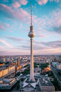 the television tower in berlin, germany is seen from above at sunset with pink clouds