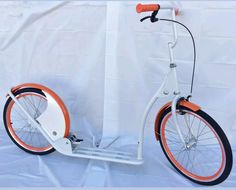 an orange and white scooter is against a white background with the seat down