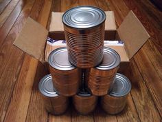 a stack of tin cans sitting on top of a wooden floor