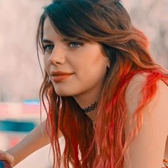 a woman with red hair and blue eyes is posing for the camera while wearing a necklace