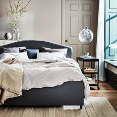 a bedroom with a bed, nightstands and table in it's center area