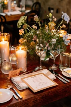 the table is set with place settings and candles