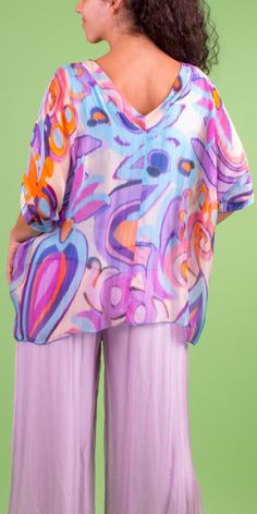 V-Neck Silk Blouse Featuring a Colorful Swirl Print. Short Sleeved Finished with Wide Double-Layered Hem. Exterior 100% Silk | Interior 95% Viscose, 5% Elastic Model 5'8" One Size Made in Italy Silk V-neck Printed Tops, Colorful V-neck Blouse For Beach, Multicolor Silk Top With Vibrant Print, Patterned Abstract Print V-neck Top, Multicolor Silk Tops With Vibrant Print, Spring V-neck Top With Colorful Pattern, Flowy Vibrant Print Blouse, Spring Flowy Tops With Vibrant Print, Patterned Flowy V-neck Blouse