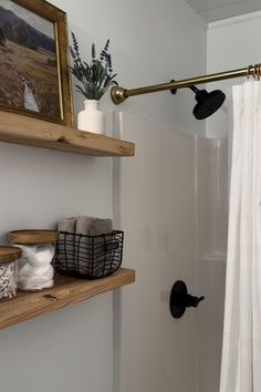 a bathroom with white walls and wooden shelves