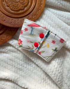 a close up of a cloth on top of a wooden tray with an object in the background