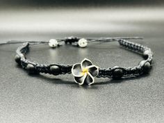 Matte black Onyx (natural) stones Plumeria hawaiian Flower Beautiful beaded hemp choker! * Hand-crafted square knot macrame * Adjustable * Opens up to 31" to fit overhead * 100% 1mm hemp cord * Slide knot closure for easy removal This hemp choker is made in traditional macrame square knots with black hemp and with natural matte onyx stones . Each of these beachy boho choker necklace is made adjustable for OSFM. Please message me with any questions. Thank you for choosing handmade and supporting Black Bohemian Necklace With Sliding Knot, Adjustable Black Flower Jewelry, Traditional Black Jewelry With Adjustable Cord, Hand Wrapped Black Jewelry For Beach, Hand Wrapped Black Beach Jewelry, Black Bohemian Jewelry With Adjustable Cord, Bohemian Black Jewelry With Adjustable Cord, Bohemian Black Jewelry With Sliding Knot, Black Macrame Jewelry For Festivals