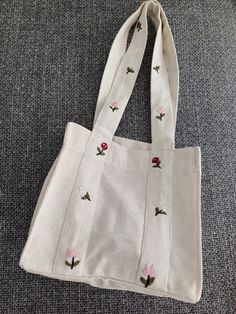 This unique handmade embroidered flower bag is a perfect accessory that combines natural charm with elegance. Made from high-quality and durable fabric, this bag features meticulously embroidered flower motifs that catch the eye. Features: Material: High-quality natural fabric Dimensions: Width: 28 cm, Height: 26 cm, Depth: 14 cm Embroidery: Handmade flower motifs Color: Cream/beige  Usage: Ideal for daily use, shopping, beach trips, or adding a touch of elegance to special occasions Carrying: W Flower Motifs, Floral Bags, Flower Bag, Beach Trips, Natural Fabric, Simple Flowers, Handmade Flower, Cream Beige, Bag Handmade