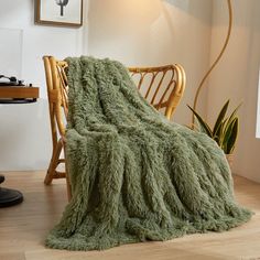 a green blanket sitting on top of a wooden chair