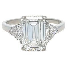 This absolutely stunning three stone diamond ring by Cartier features a 3.00 carat emerald cut diamond with F color and VS1 clarity, flanked by two trillion cut diamonds weighing approximately 1.00 carat total. Mounted in platinum and crafted with the highest of quality, this ring is sure to be cherished for a lifetime. Stamp: 10% IRID. PLAT. Car(obscured) 862531 Ring size: 7 3/4 Metal: Platinum Total Weight: 5.80 grams GIA, 2024, Report No. 6234216267, 3.00 carats, F color, VS1 clarity, No fluorescence Side Diamond Characteristics (insofar as the mounting permits): Color: F Clarity: VS1 and SI1 Classic Cartier Rings With Prong Setting, Cartier Diamond Ring With Vvs Clarity In Platinum, Cartier Platinum Diamond Ring With Vvs Clarity, Gia Certified Trillion Cut Diamond Ring For Formal Events, Gia Certified Trillion Cut Diamond Ring For Formal Occasions, Gia Certified Trillion Cut Diamond Ring, Classic Cartier Diamond Ring In Diamond White, Classic Cartier Diamond White Diamond Ring, Classic Cartier Platinum Diamond Ring