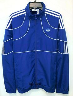 ADIDAS ORIGINALS ORIGINALS 2K TECH TRACK JACKET  Size: Small Color: Blue MSRP: $90 100% Authentic Guaranteed Football style from the 2000s inspires this men's track jacket. A Trefoil outline and geometric angles create a clean, minimalist design. Deconstructed contrast 3-Stripes are a fresh take on an iconic sporty look. - Funnel neck - Long sleeves - Front zip closure - Piping trim - 3-stripe and logo details - Dual front pockets - Lined - Imported Machine wash 100% polyester Measurements: plea Adidas Nylon Track Jacket For Streetwear, Technical Moisture-wicking Track Jacket For Streetwear, Spring Streetwear Track Jacket With Side Stripes, Sportswear Nylon Track Jacket With Adidas Logo, Adidas Technical Track Jacket For Streetwear, Adidas Blue Outerwear With Three Stripes Branding, Adidas Blue Outerwear With Three Stripes, Adidas Nylon Track Jacket, Blue Nylon Track Jacket For Spring