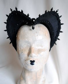 The Countess is an impressive gothic attifet headdress.This vampire style headdress is covered with black silk shantung and embellished with black cord trimming all around the edges.It is further trimmed with black crystal details that create a halo effect as well as small black crystal beads that were hand-sewn on the trimming to create rich textural interest. The piece is completed with a black crystal handmade element placed at the center front for all that extra drama that we all love! The h Black Fitted High Crown Costume Hat, Gothic High Crown Costume Accessories For Costume Party, Fantasy High Crown Costume Accessories For Halloween, Fantasy High Crown Halloween Costume Accessories, Black Fantasy Cat Ears Costume Accessories, Black Cat Ears Fantasy Costume Accessories, Fitted Black Cat Ears Costume Accessories, Fitted Black Headpiece For Evening, Gothic High Crown Headpiece For Costume