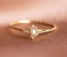 a close up view of a gold ring with pearls and diamonds on the side,