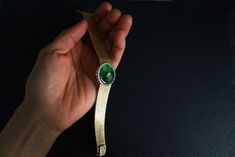 "Fine watch bracelet set with a jade donut and accented with diamonds in 18k. The donut is a deep green Omphacite jade, in parts dark and light like a globe lit. This jewel borrows the perfect finish of a Vacheron watch, its Omega straps in original burnished solid gold. More than a conversion piece, this bracelet could not have been refined to a sleeker layout. At 2cm, the donut is considered big yet its size is offset by the straps, and vice versa. The straps though wide feel made for its cent Fine Jade Jewelry For Formal Occasions, Modern Green Jewelry For Formal Occasions, Green Polished Jewelry For Evening, Timeless Green Bracelet For Formal Occasions, Timeless Green Bracelets For Formal Occasions, Elegant Green Watch As A Gift, Luxury Jade Bracelets For Formal Occasions, Green Cabochon Jewelry For Evening, Polished Green Jewelry For Evening