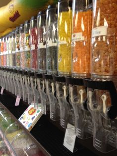 a store filled with lots of different types of candy in plastic containers and on the shelves