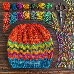 a knitted hat next to some beads and scissors