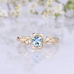 an engagement ring with a blue topazte surrounded by white flowers